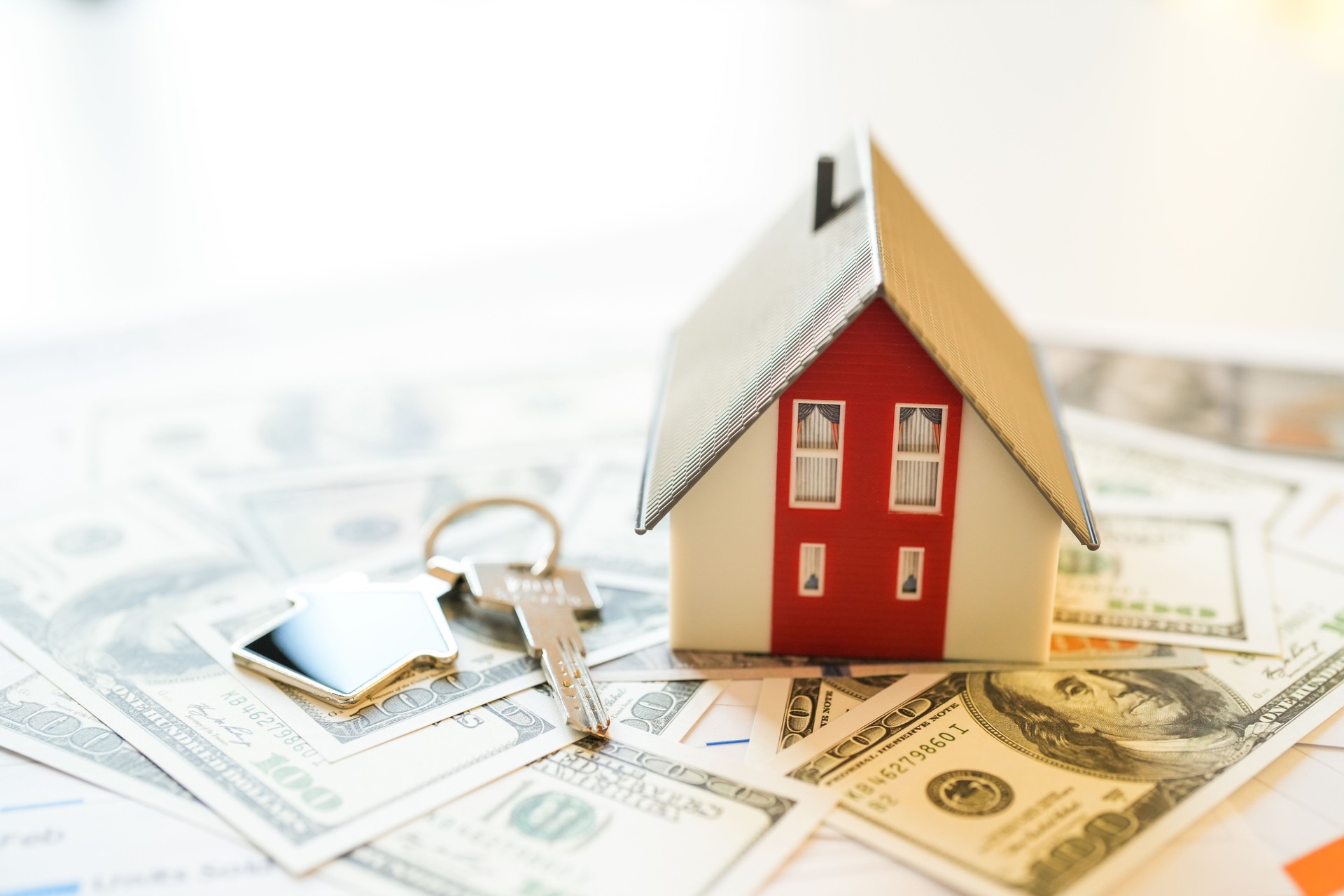 Miniature house on dollars on table. Real estate sales, house sales in America